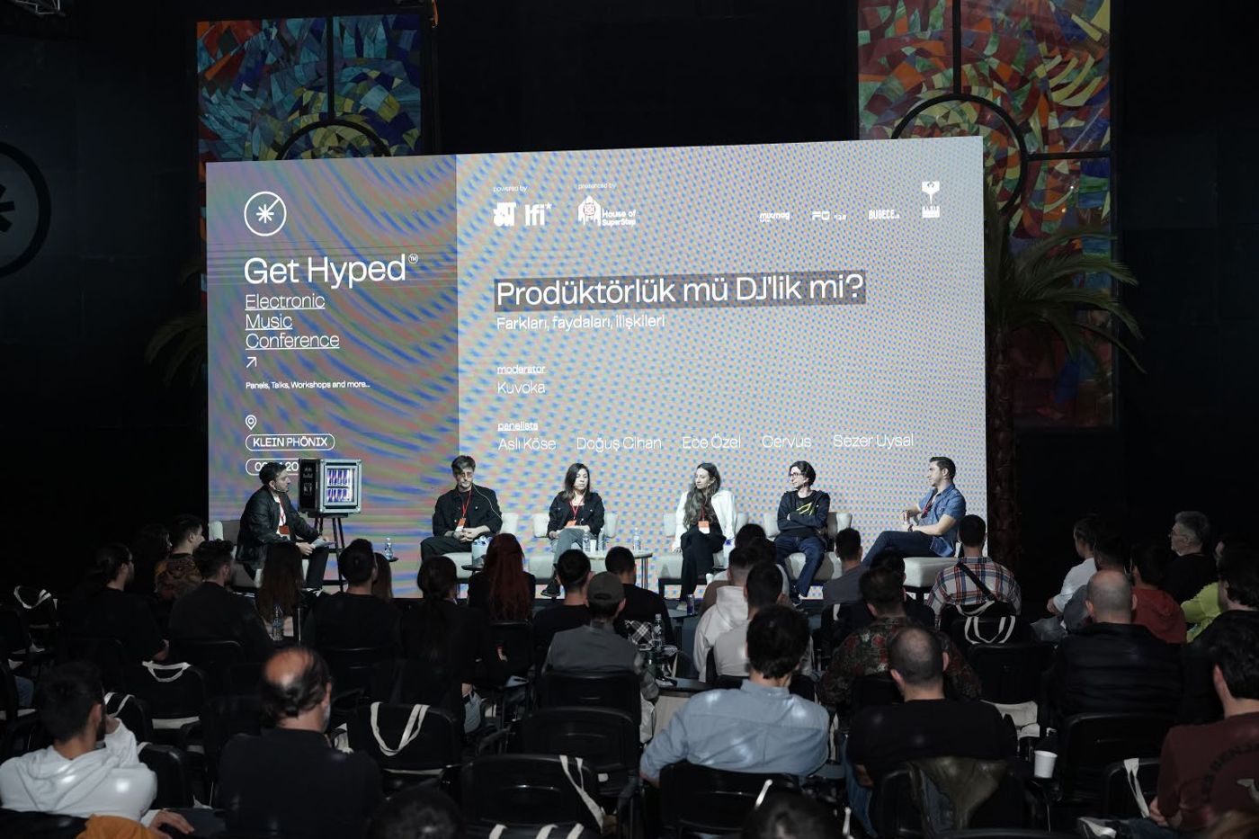 Panel “Prodüktörlük mü DJ’lik mi?” on stage in front of a full audience